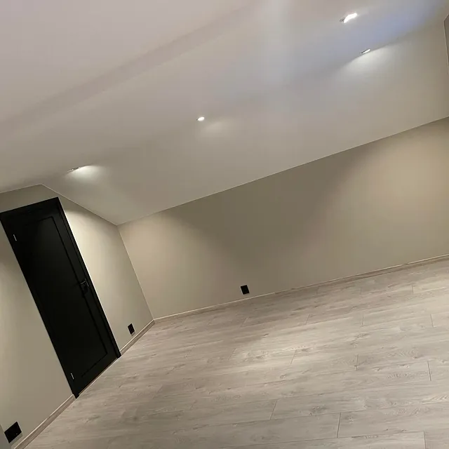 Nyrenovert rom med skråtak. Lyse vegger og detaljer i svart